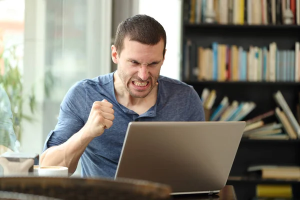 Dühös felnőtt férfi ellenőrzi laptop online tartalom egy bárban — Stock Fotó