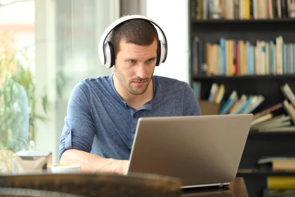 Dospělý muž nosí sluchátka pomocí notebooku — Stock fotografie