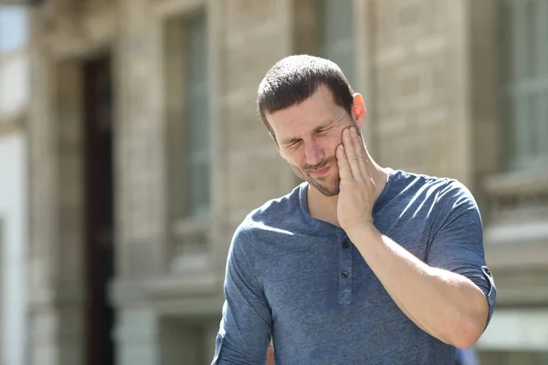 Stressed man suffering tooth ache in the street — Stock Photo, Image