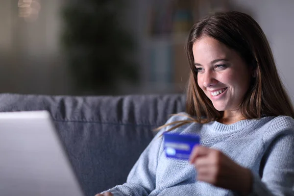 Mujer feliz utilizando el ordenador portátil y tarjeta de crédito para comprar en línea — Foto de Stock