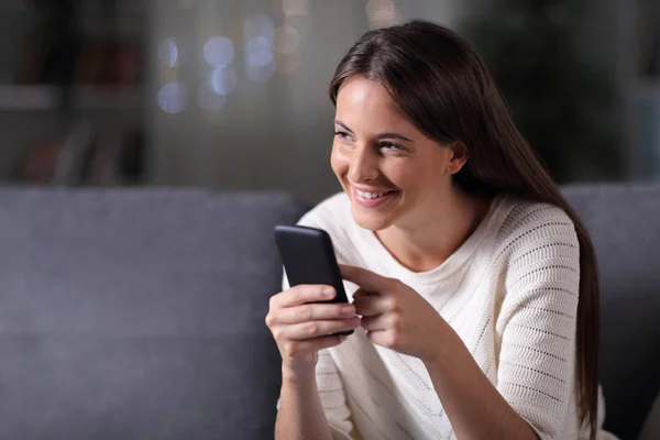 Happy girl holding phone thinks looking at side — Stock Photo, Image