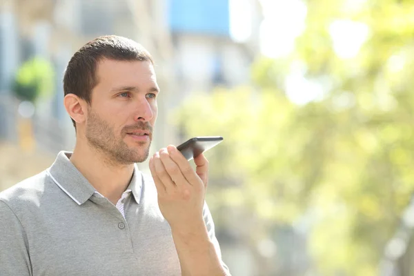 Uomo che usa il riconoscimento vocale al telefono in strada — Foto Stock