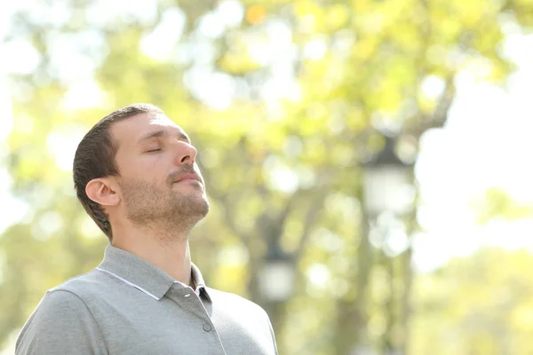 Χαλαρός άνθρωπος αναπνέει βαθιά καθαρό αέρα έξω σε ένα πάρκο — Φωτογραφία Αρχείου