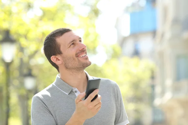 Hombre adulto sosteniendo teléfono búsqueda ubicación en la calle —  Fotos de Stock