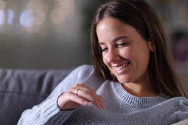 Mutlu gelin evde nişan yüzüğüne bakıyor.