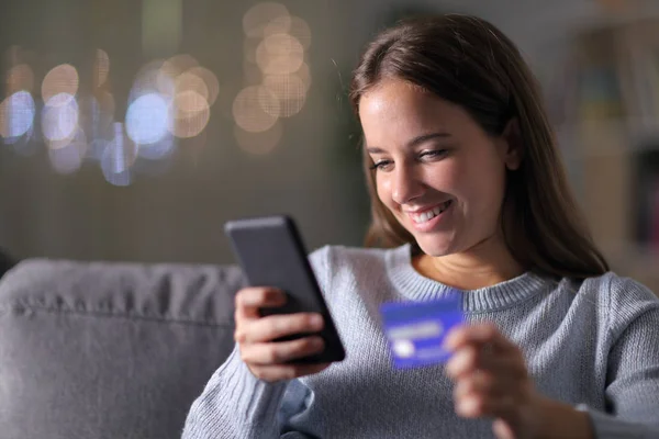 Evde telefon ve kredi kartıyla alışveriş yapan mutlu bir kadın. — Stok fotoğraf