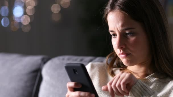 Сумна Жінка Читає Вміст Мобільного Телефону Сидячи Дивані Вдома Вночі — стокове відео