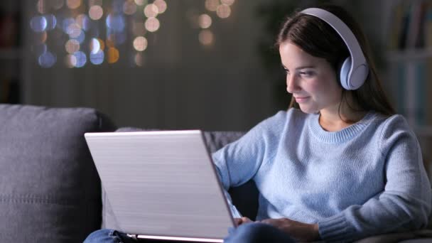 Skoncentrowana Kobieta Nosząca Słuchawki Pisząca Laptopie Siedząca Kanapie — Wideo stockowe