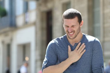 Strese girmiş yetişkin bir adam sokakta göğüs ağrısı çekiyor.