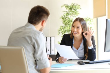 Menajer elinde özgeçmiş tutan bir adamla görüşüyor.
