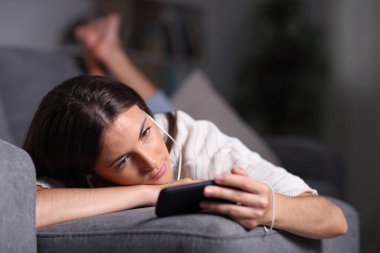 Rahat kız telefonda film izliyor ve dinliyor.