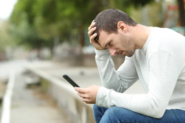 Triste hombre adulto comprobando malas noticias en el teléfono inteligente —  Fotos de Stock