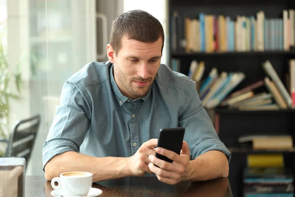 Розслаблений чоловік використовує смартфон у кав'ярні — стокове фото