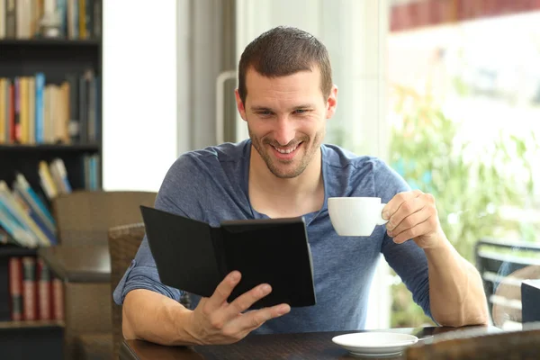 Homem feliz lendo um ebook em um café — Fotografia de Stock