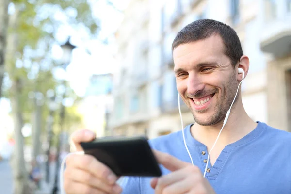 Счастливый взрослый мужчина смотрит видео на мобильном телефоне — стоковое фото