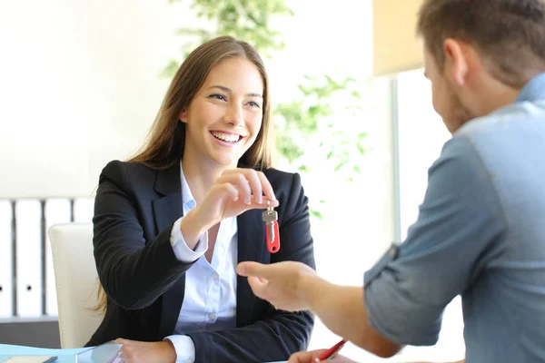 Inmobiliaria dando llaves de la casa a un cliente en la oficina — Foto de Stock