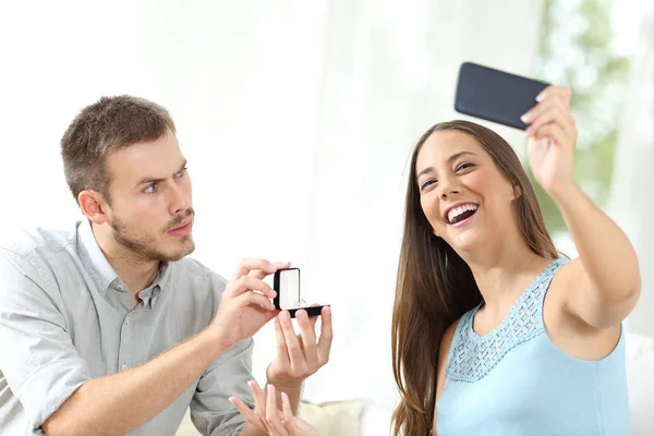 Hombre molesto proponiendo matrimonio y novia tomando selfie —  Fotos de Stock