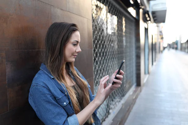 Menina séria verifica telefone inteligente na rua — Fotografia de Stock