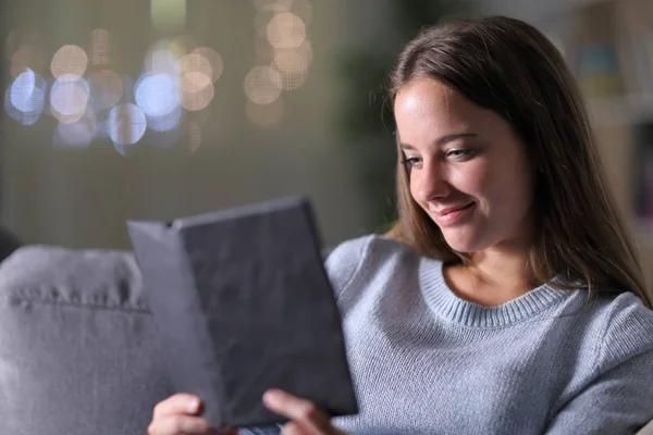 Ontspannen vrouw leest een ebook in de nacht thuis — Stockfoto