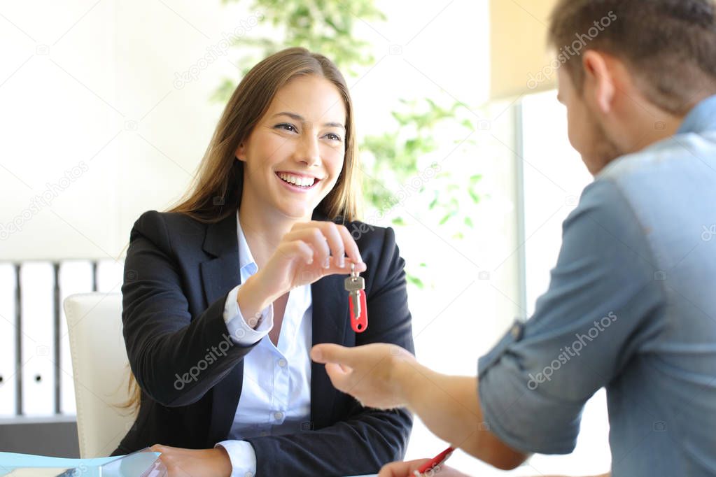 Realtor giving house keys to a client at office