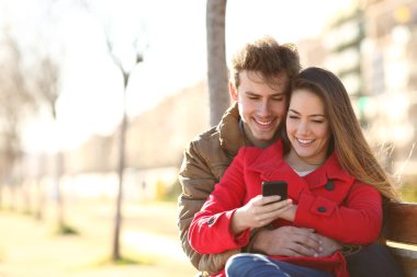 Mutlu çift akıllı bir telefonla geziniyor.