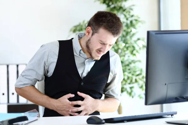 Jovem executivo sofrendo dor de barriga no escritório — Fotografia de Stock
