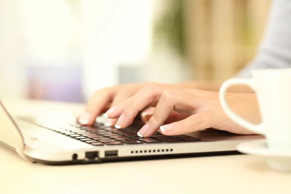 自宅の机の上に座ってノートパソコンのキーボードを入力する女性の手の閉じる — ストック写真