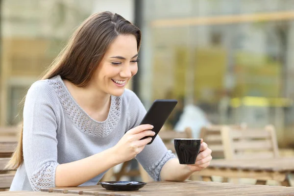 Mujer Feliz Revisando Teléfono Inteligente Sosteniendo Taza Sentada Terraza Una —  Fotos de Stock