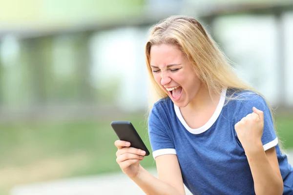 Heyecanlı Genç Kız Parkta Akıllı Telefondan Iyi Haberi Kutluyor — Stok fotoğraf