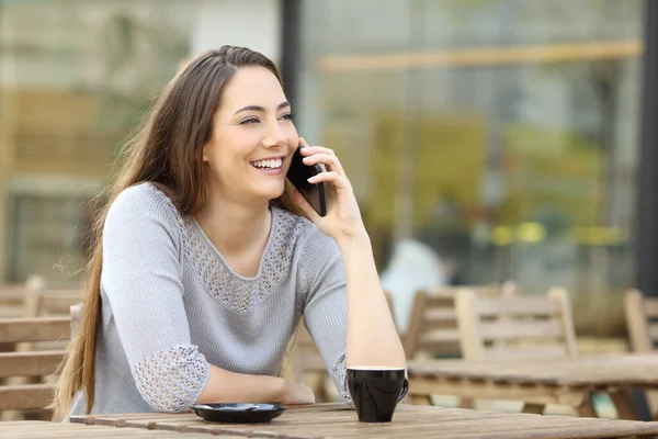 幸せな女性を呼び出す上のスマートフォンに座ってコーヒーショップテラステーブル — ストック写真