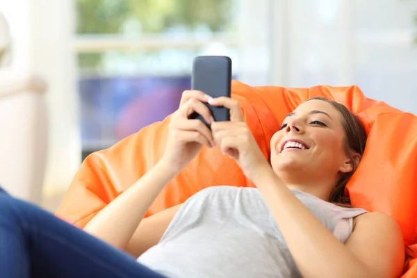 Mujer Feliz Escribiendo Teléfono Inteligente Acostado Una Bocanada Sala Estar — Foto de Stock