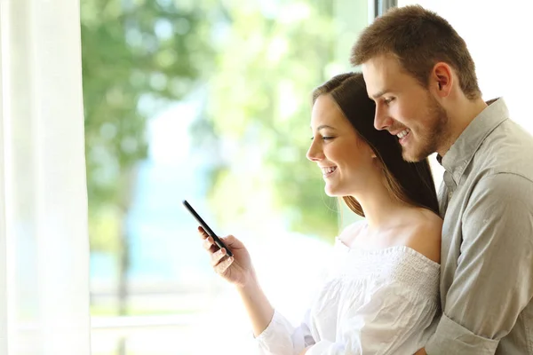 Side View Couple Checking Smart Phone Standing Next Window Home — Stock Photo, Image