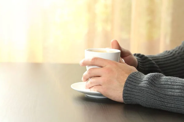 Närbild Man Händer Håller Kaffekopp Sitter Ett Bord Vid Fönstret — Stockfoto