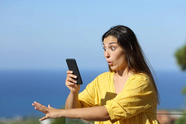 Överraskad Kvinna Kontrollerar Smart Telefon Hotellbalkong Stranden Sommarsemester — Stockfoto
