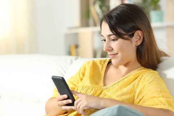 Chica Amarillo Usando Teléfono Móvil Sentado Sofá Sala Estar Casa — Foto de Stock