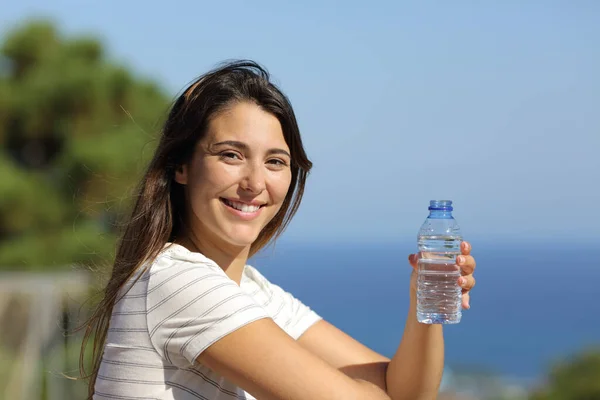 Счастливая Женщина Бутылкой Воды Смотрит Тебя Балконе Пляже — стоковое фото