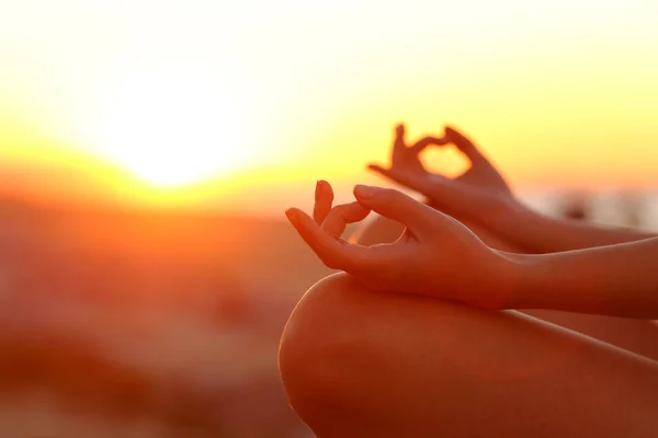 Close up of woman hands stress relieving doing yoga exercise at sunset outdoor