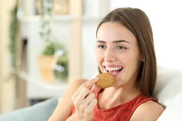 Happy Woman Eating Cereal Cookie Sitting Couch Living Room Home — Stock Photo, Image