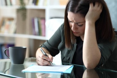 Evdeki oturma odasında oturan üzgün kadın şikayetçi.