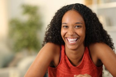 Mükemmel gülüşü olan mutlu siyah bir kadının portresi sana bakıyor.