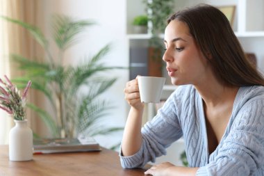 Kadın serinletici, üflemeli evde oturuyor.