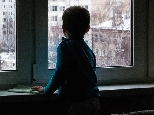 Küçük bir çocuk pencereden dışarı bahar ya da bir şey için bekleyen görünüyor... Kar yağıyordu ve dışarısı soğuk
