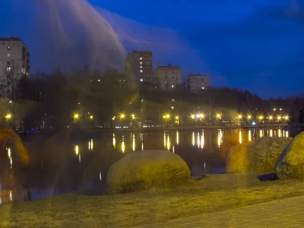 Teich im Park bei Nacht, Menschen gehen vorbei. — Stockfoto