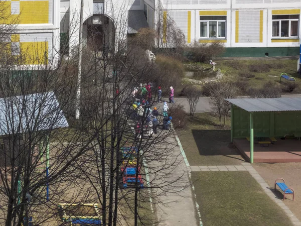 Inizio primavera. Il sole splende. I bambini giocano in cortile. Scuola materna — Foto Stock