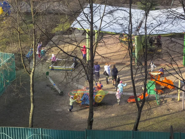 Inizio primavera. Il sole splende. I bambini giocano in cortile. Scuola materna — Foto Stock