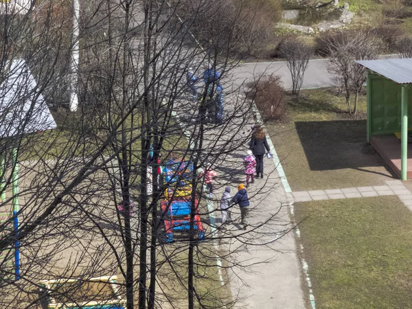 İlkbaharın başlarında. Güneş parlıyor. Çocuklar bahçede oynar. Anaokulu — Stok fotoğraf