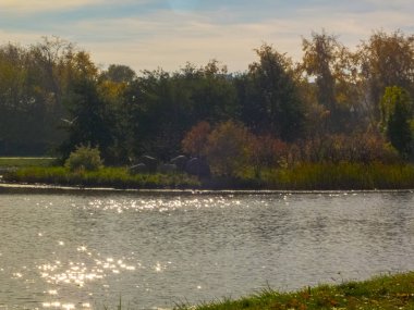 Sonbahar saati, şehirde sonbahar, bir gölet ile kentsel sonbahar manzara, insanlar yürüyüş ve diğer eğlenceli