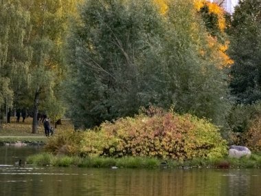 Sonbahar saati, şehirde sonbahar, bir gölet ile kentsel sonbahar manzara, insanlar yürüyüş ve diğer eğlenceli