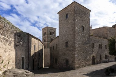 Antik taş binalar ve kilise kulesi Trujillo, İspanya 'da mavi gökyüzünün altında büyüleyici bir sahne yaratıyor.