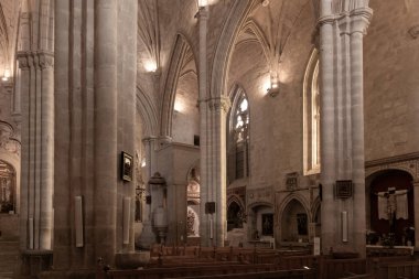 İçinde kemerler, sütunlar ve ahşap sıralar olan gotik mimari barındıran tarihi kilise iç mimarisi.